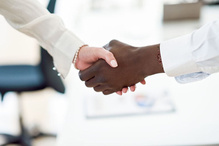 Two women shaking hands during an interview
